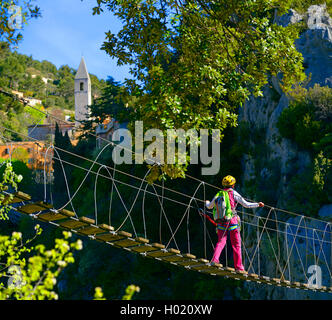 Climber sur suspension pont traversant une gorge, une Escale Via ferrata Peille, France, Cotes D. Azur, Peille Banque D'Images