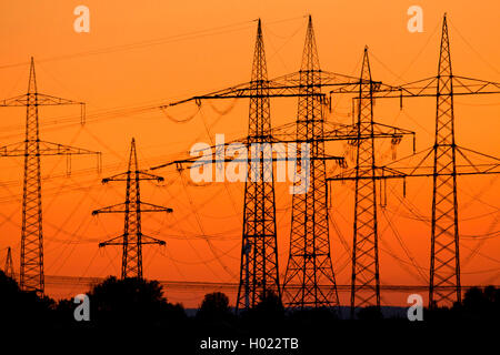 Poteaux d'électricité en rouge ciel du soir, Allemagne Banque D'Images