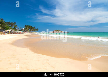 Le Weligama, SRI LANKA - 5 mars 2014 : les touristes sur une belle plage de sable. Le tourisme et la pêche sont deux activités principales dans cette ville. Banque D'Images