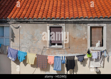 Du linge propre séchant sur la corde en face de la vieille maison. Banque D'Images