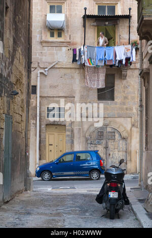 MELLIEHA, MALTE - 10 janvier 2015 : scooter et voiture garée dans la rue étroite Mellieha. Banque D'Images