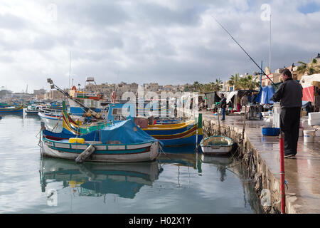 MARSAXLOKK, MALTE - 11 janvier 2015 : pêcheur sur le quai à côté du marché de Marsaxlokk, l'une des principales caractéristiques especiall Banque D'Images