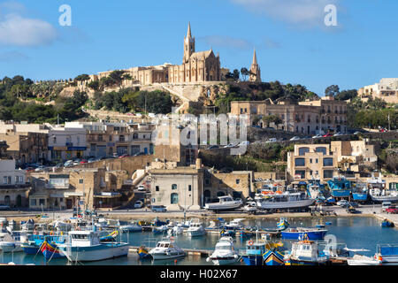 MGARR, MALTE - 13 janvier 2015 : Mgarr Harbour avec vue sur l'église de Notre Dame de Lourdes sur le haut de la colline. Banque D'Images