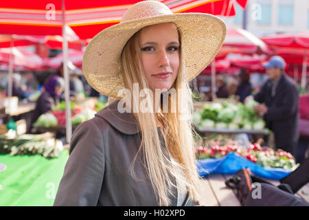 Portrait of attractive blonde fille avec chapeau de paille sur le marché. Banque D'Images