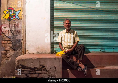 VARANASI, INDE - 19 février 2015 : Indian homme est assis en face de magasin fermé. Banque D'Images