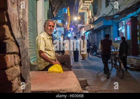 VARANASI, INDE - 19 février 2015 : Indian homme est assis en face de magasin fermé. Banque D'Images