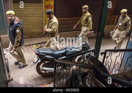 VARANASI, INDE - 20 février 2015 : Quatre policiers indiens à pied sur la rue de l'ancienne partie de Varanasi et passer par moto en stationnement. Banque D'Images