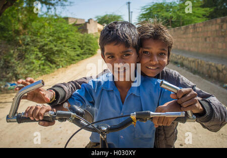 Région GODWAR, INDE - 15 février 2015 : deux garçons sur un vélo dans la rue village vide. Banque D'Images