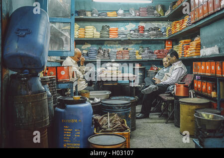 JODHPUR, INDE - 07 février 2015 : propriétaire de spice store front massages après une longue journée de travail alors que les clients discuter busines Banque D'Images