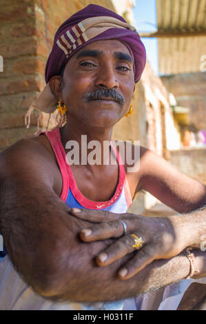 Région GODWAR, INDE - 14 février 2015 : mécanicien avec moustache portant foulard et grandes boucles d'or se trouve à l'extérieur de worksho Banque D'Images