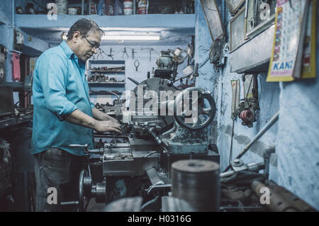 JODHPUR, INDE - 17 février 2015 : mécanicien travaillant tard en atelier avec des équipements et des machines. Post-traités avec Banque D'Images