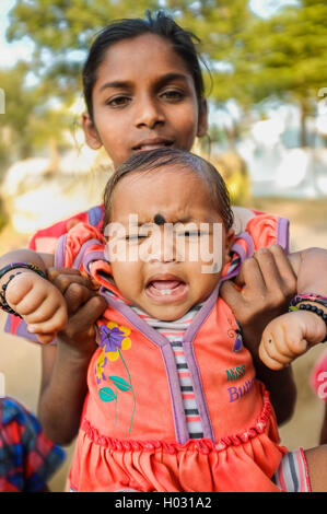 HAMPI, INDE - 31 janvier 2015 : avec bébé indien bindi pleurer alors qu'il était détenu par un membre de la famille Banque D'Images