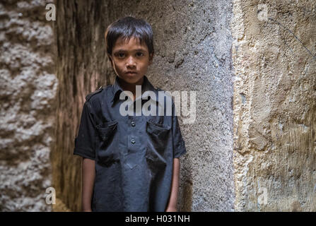 MUMBAI, INDE - 12 janvier 2015 : jeune garçon indien du bidonville de Dharavi est vide dans la rue étroite en chemise noire. Banque D'Images