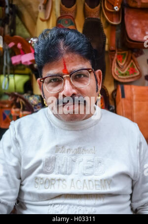 JODHPUR, INDE - 07 février 2015 : propriétaire du magasin avec moustache portant des lunettes, boucles d'or et bindi assis en face du magasin. Ra Banque D'Images