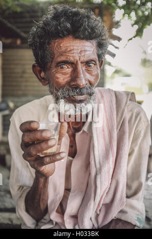 HAMPI, INDE - 31 janvier 2015 : personnes âgées Indien détient un verre de chai. Post-traités avec le grain, la texture et l'effet de couleur. Banque D'Images