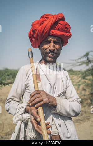 Région GODWAR, INDE - 13 février 2015 : Rabari tribesman détient sur ax traditionnel champ. Post-traités avec grain, texture et Banque D'Images