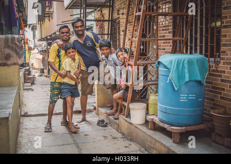 MUMBAI, INDE - 16 janvier 2015 : cinq membres de la famille se tenir ensemble dans la rue des taudis. Post-traités avec grain, texture et colou Banque D'Images