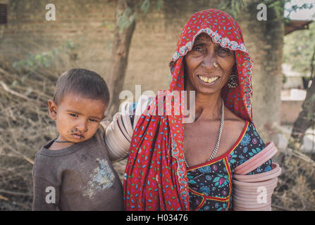 Région GODWAR, INDE - 15 février 2015 : personnes âgées tribeswoman indien porte les vêtements traditionnels de la décoration. Bébé a des mouches autour Banque D'Images