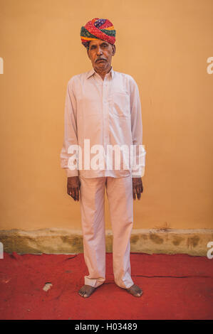 Région GODWAR, INDE - 15 février 2015 : Indian man poses en-avant du mur vide sur le tapis rouge portant des vêtements blancs et Banque D'Images