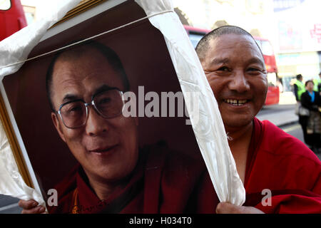 Moine tibétain avec une image encadrée de Dalaï Lama lors de la manifestation pour le Tibet libre, Londres, Royaume-Uni. Banque D'Images