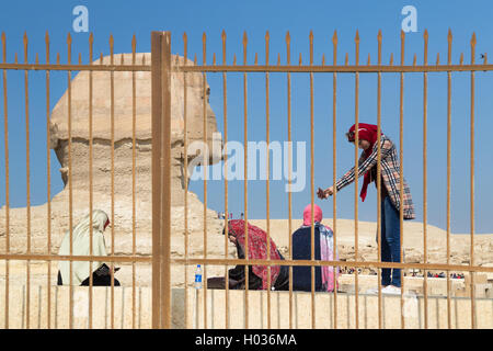 Le CAIRE, ÉGYPTE - 3 février 2016 : les touristes avec des téléphones cellulaires en face de la tête du grand Sphinx de Gizeh. Banque D'Images