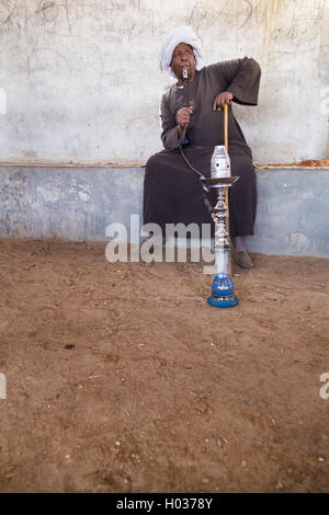 DARAW, EGYPTE - 6 février, 2016 : Vendeur de chameau Local fumeurs shisha pipe. Banque D'Images