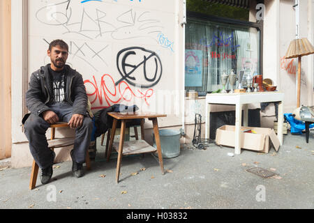 ZAGREB, CROATIE - le 17 octobre 2013 : les jeunes Roms l'homme assis à la présidence au dépotoir de la rue. Banque D'Images