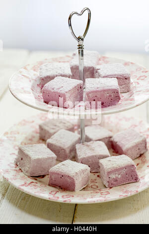 Blackberry fait maison et les guimauves rose sur un stand de gâteau rose. Banque D'Images