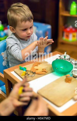 Petit garçon être créatif avec de la pâte à modeler Banque D'Images