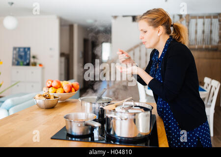 Femme au foyer cuisine dans une cuisine moderne Banque D'Images