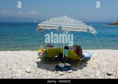 Deux femmes sous un parasol sur la plage de Avlaki, les îles Ioniennes Corfou, Grèce, Europe Banque D'Images