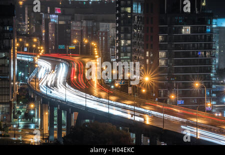 Des traînées de lumière brillante et une autoroute Gardiner humide que le trafic ne s'arrête jamais. Banque D'Images