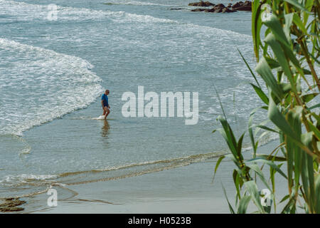 Homme marchant le long de la mer dans la plage Trengandin, Noja, Cantabria, Espagne. Banque D'Images