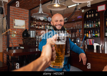 Homme barbu en Bar Clink Glasses Toasting, boire de la bière Maintenez des tasses, Cheerful Friends Meeting Banque D'Images