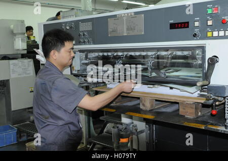 L'homme chinois travaillant dans une imprimerie moderne, Shenzhen, province de Guangdong, en Chine. crédit : Kraig Lieb Banque D'Images