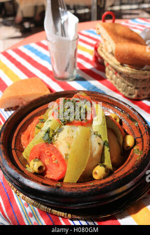 Restaurant en plein air le dîner composé de poulet et légumes servi dans un tajine en terre cuite, au Maroc Banque D'Images