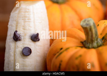 Les citrouilles et fantômes faits avec banane et chocolat pour l'halloween sur du bois Banque D'Images