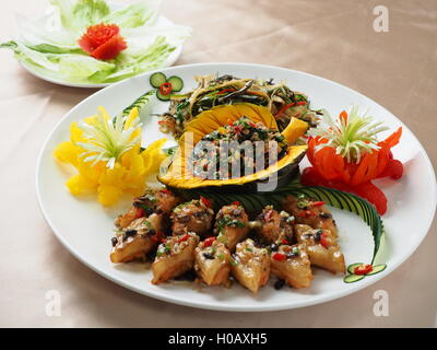 Émincé de porc frit avec salade de citrouille sur plaque blanche dans un restaurant asiatique Banque D'Images