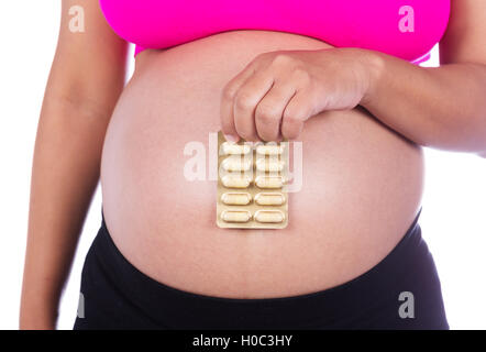 Femme enceinte avec distributeur de comprimés dans ses mains isolé sur fond blanc Banque D'Images