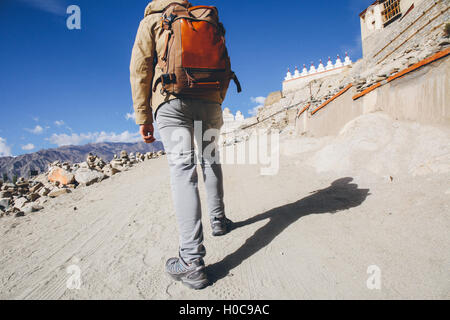 Close-up of male traveler walking uphill sur dune de sable menant au monastère à Leh, Ladakh, Inde Banque D'Images