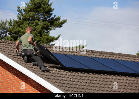 L'installation de panneau solaire sur le toit de l'homme dans une installation de panneaux solaires domestiques au Royaume-Uni Banque D'Images