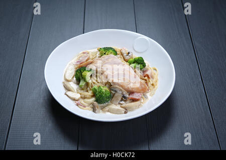 Avec poulet Carbonara aux champignons et brocoli vert on white plate Banque D'Images