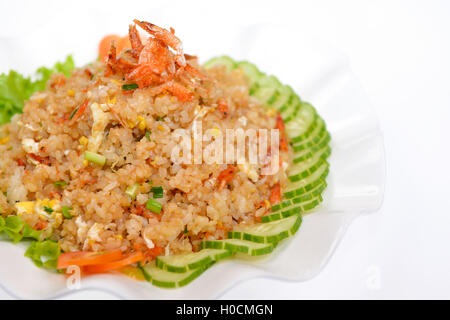 Riz frit avec des tranches de concombre et de petites crevettes séchées on white plate Banque D'Images