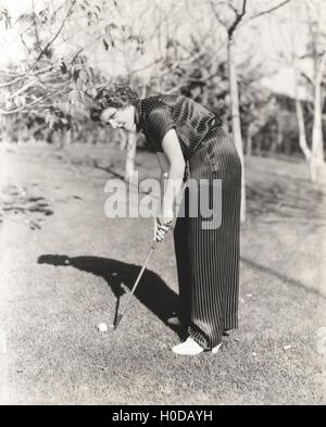 Portrait de jeune femme en jouant au golf sur terrain Banque D'Images