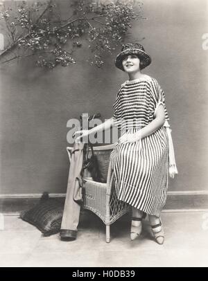 Femme en robe rayée avec clubs de golf Banque D'Images