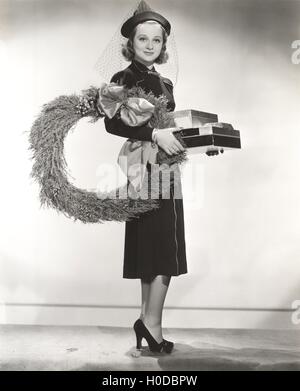 Woman in hat voilée portant couronne et des cadeaux de Noël Banque D'Images