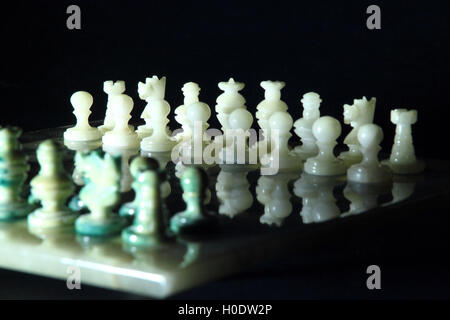 Échiquier et d'échecs d'albâtre sur un fond noir Banque D'Images