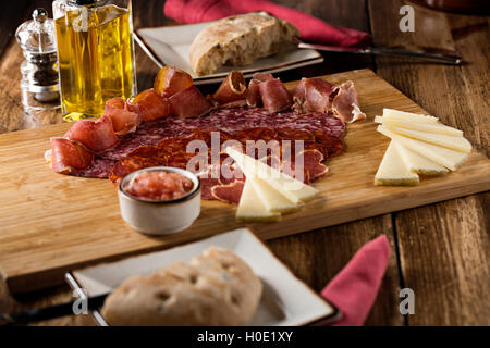 Le lard avec du fromage, du pain et d'huile d'olive sur planche à découper en bois Banque D'Images