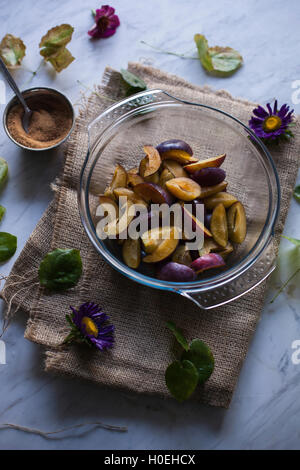 Les prunes en tranches dans un grand bol en verre, des ingrédients pour la pâtisserie plum galette Banque D'Images