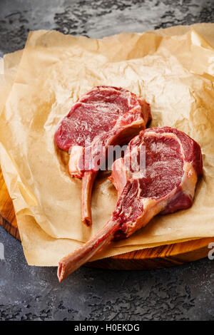 Matières de la viande fraîche bovine côte de boeuf sur l'os sur fond sombre Banque D'Images